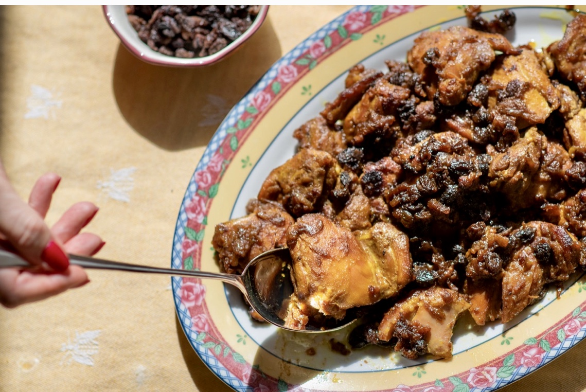 Recettes : Une assiette avec du poulet et des raisins secs dessus.