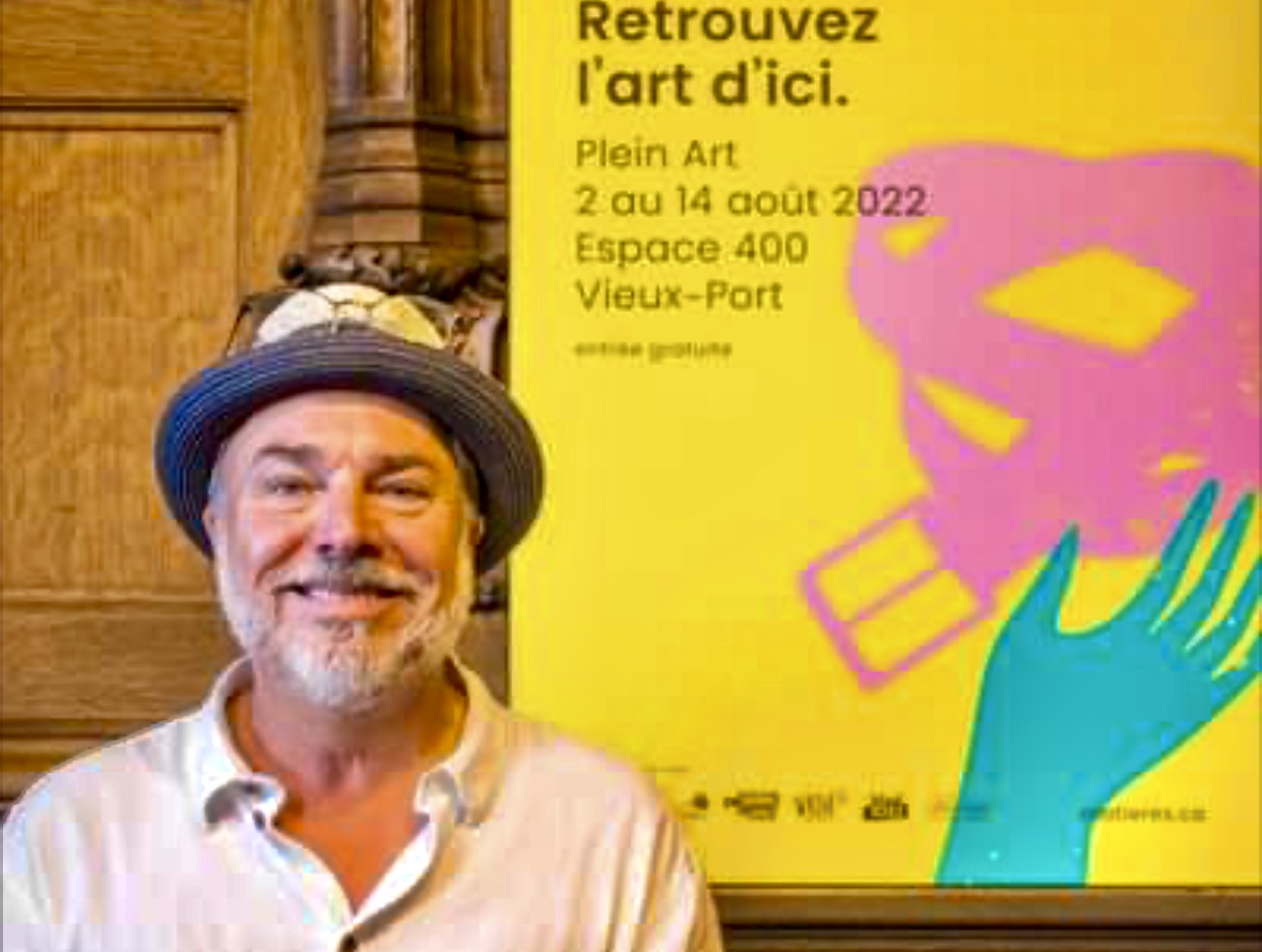 Un homme se tient devant une affiche d’arts visuels.