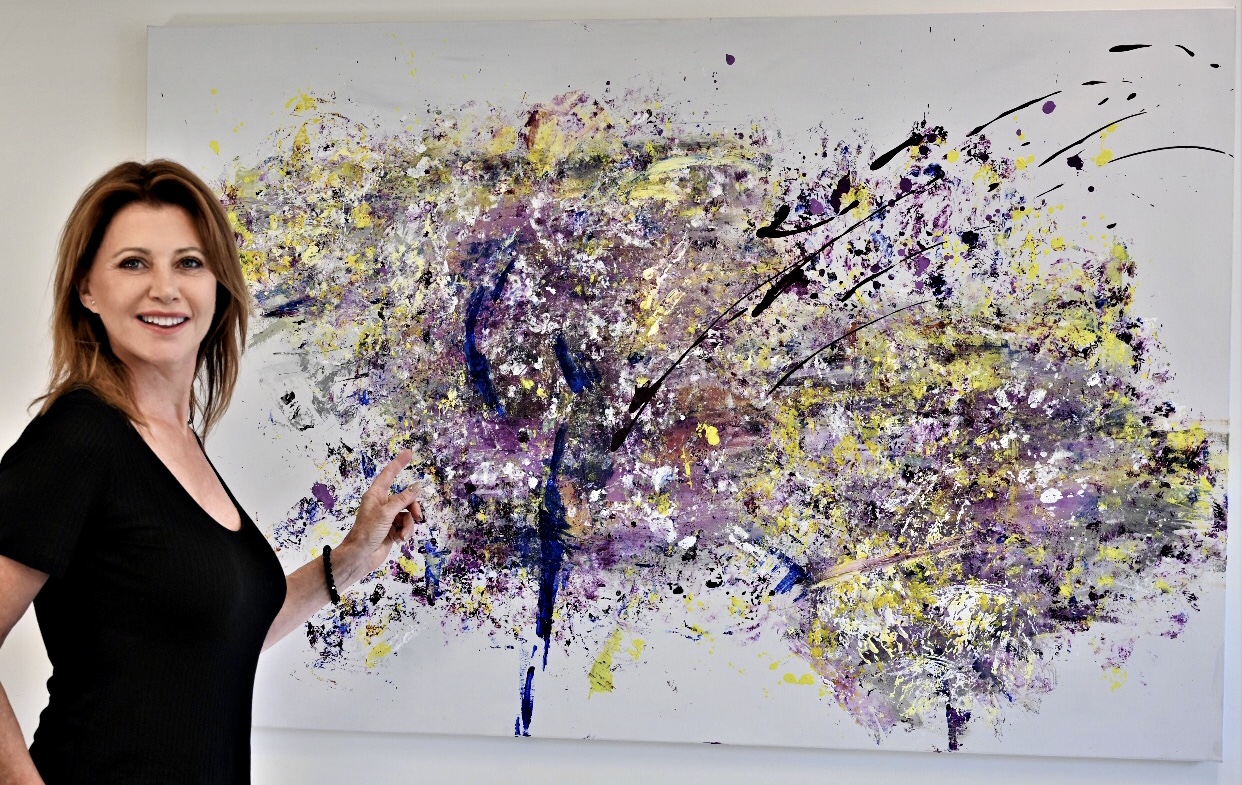 Une femme admirant une peinture abstraite lors d’une exposition Arts visuels.
