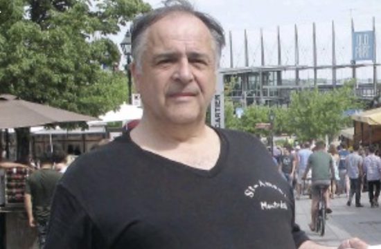 Un homme en chemise noire debout devant une foule au Spectacle au Bistro Le Rossignol.