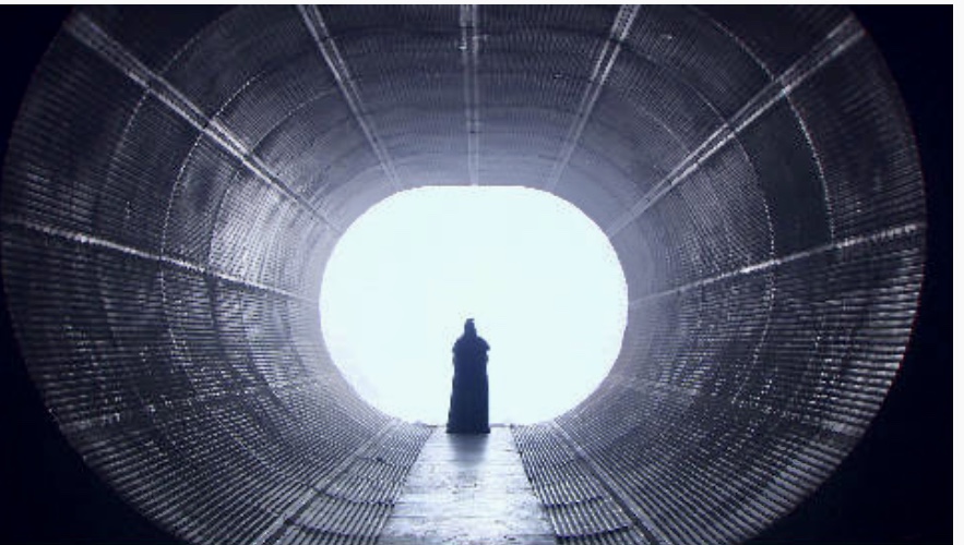 Une personne contemplant dans un tunnel sombre, explorant les profondeurs de la Philosophie.