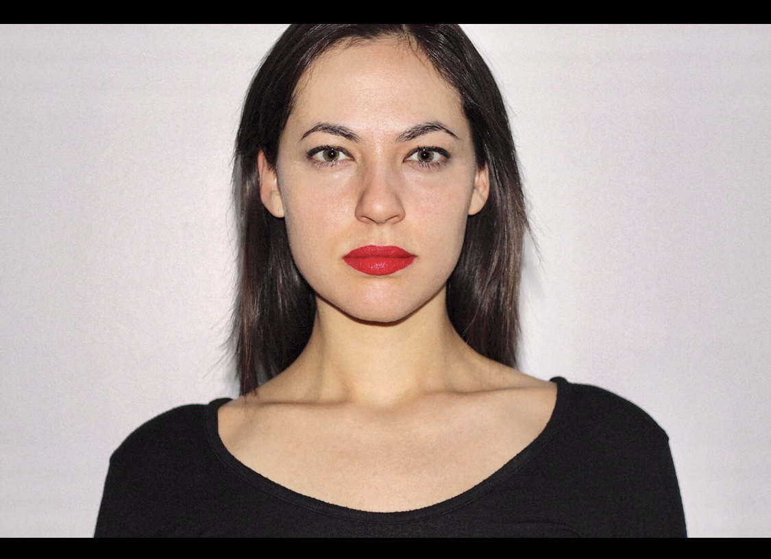 Myriam Lessard, une femme vêtue d'une chemise noire et d'un rouge à lèvres rouge, est immergée dans le monde de la culture.