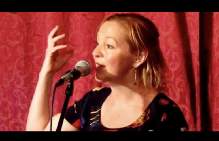 Nancy Reichl Lange donne une interview en chantant dans un micro.
