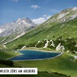 Une route de montagne avec Les Alpes suisses en arrière-plan.