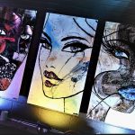 Trois peintures de femmes visuellement saisissantes ornent le mur d'un bar, incarnant l'essence de l'art visuel.
