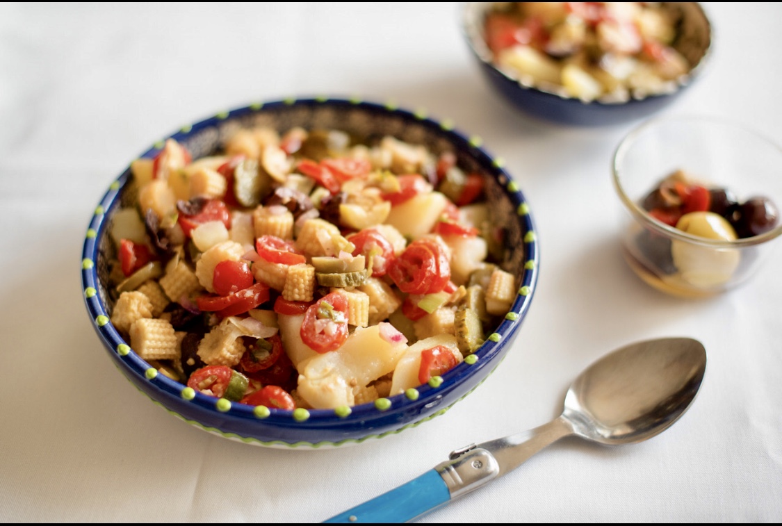Un délicieux bol de recettes de salade de pâtes avec des tomates fraîches et des olives savoureuses.