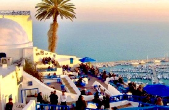 Un groupe de personnes est assise sur un balcon surplombant la mer en Tunisie.