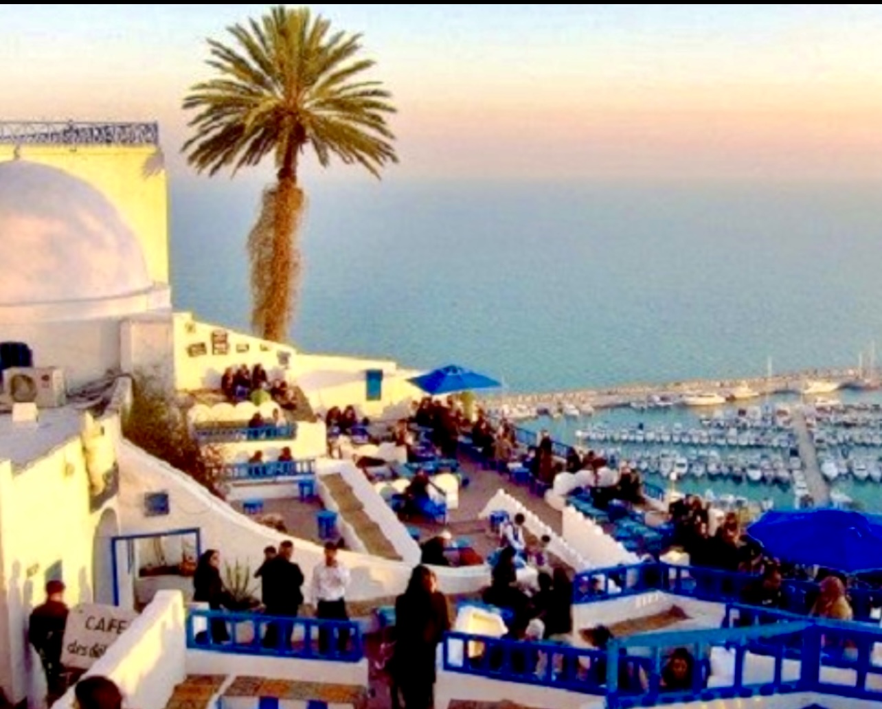 Un groupe de personnes est assise sur un balcon surplombant la mer en Tunisie.
