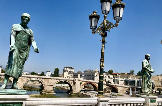 Deux statues sur un pont pittoresque au bord d'une rivière sereine.