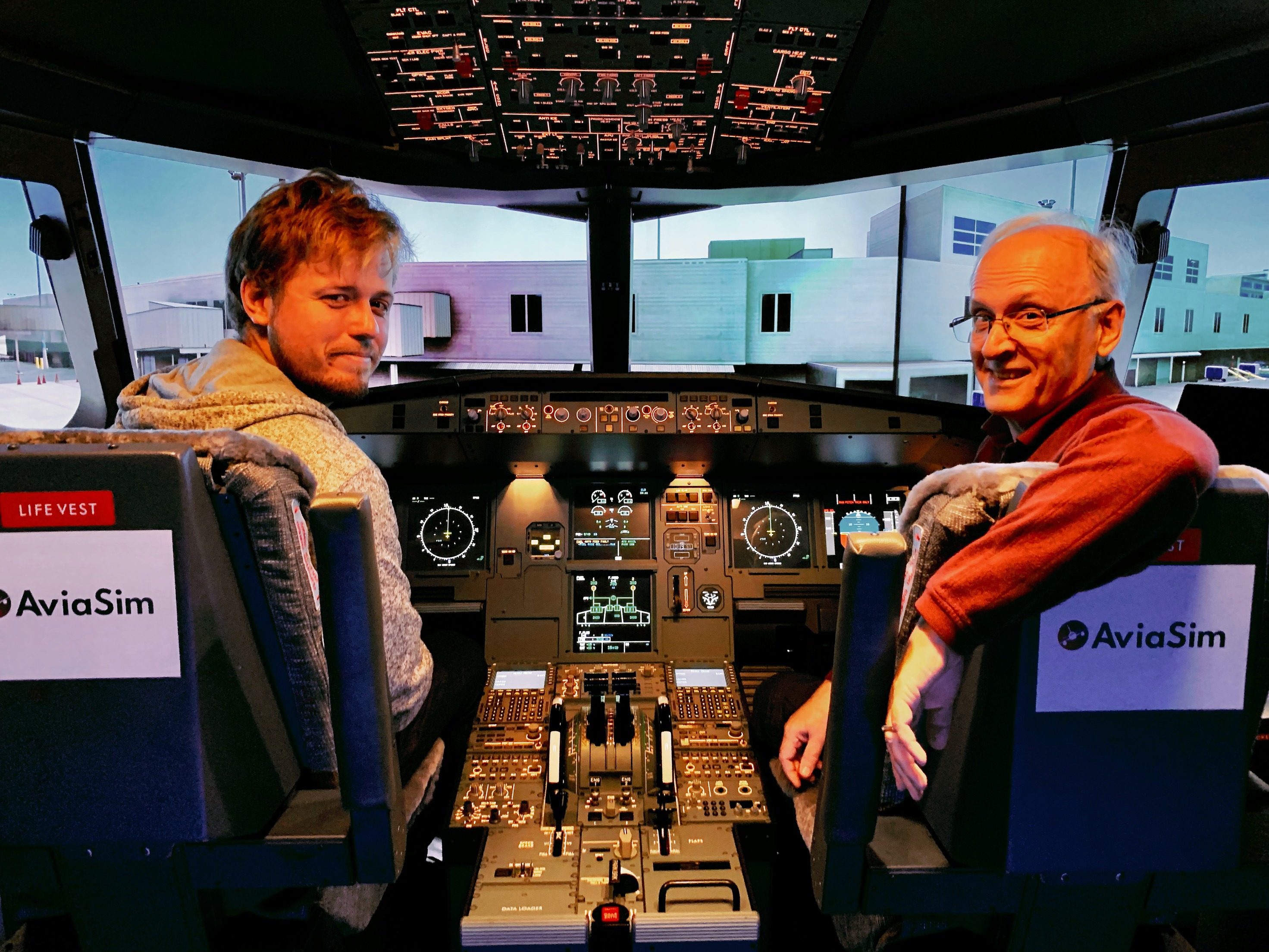 Deux hommes assis dans le cockpit d'un avion.