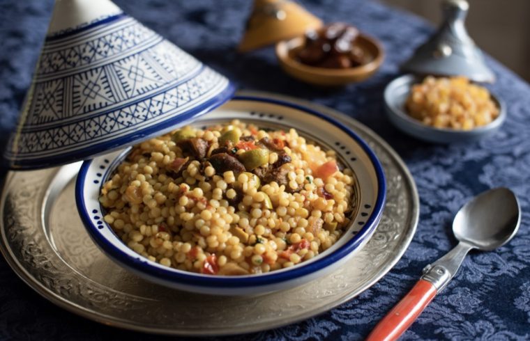 Couscous marocain aux dattes et olives dans un bol sur une table.