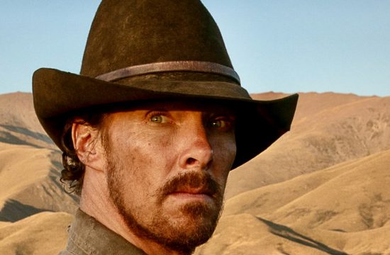 Un homme portant un chapeau de cowboy se tient dans un champ, créant une scène cinématographique.