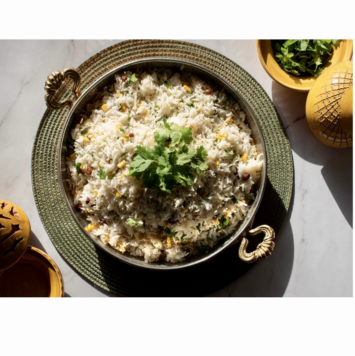 Un bol de riz sur une table à côté d'un bol de coriandre.