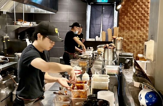 Un groupe de travailleurs préparant des plats dans un restaurant japonais.