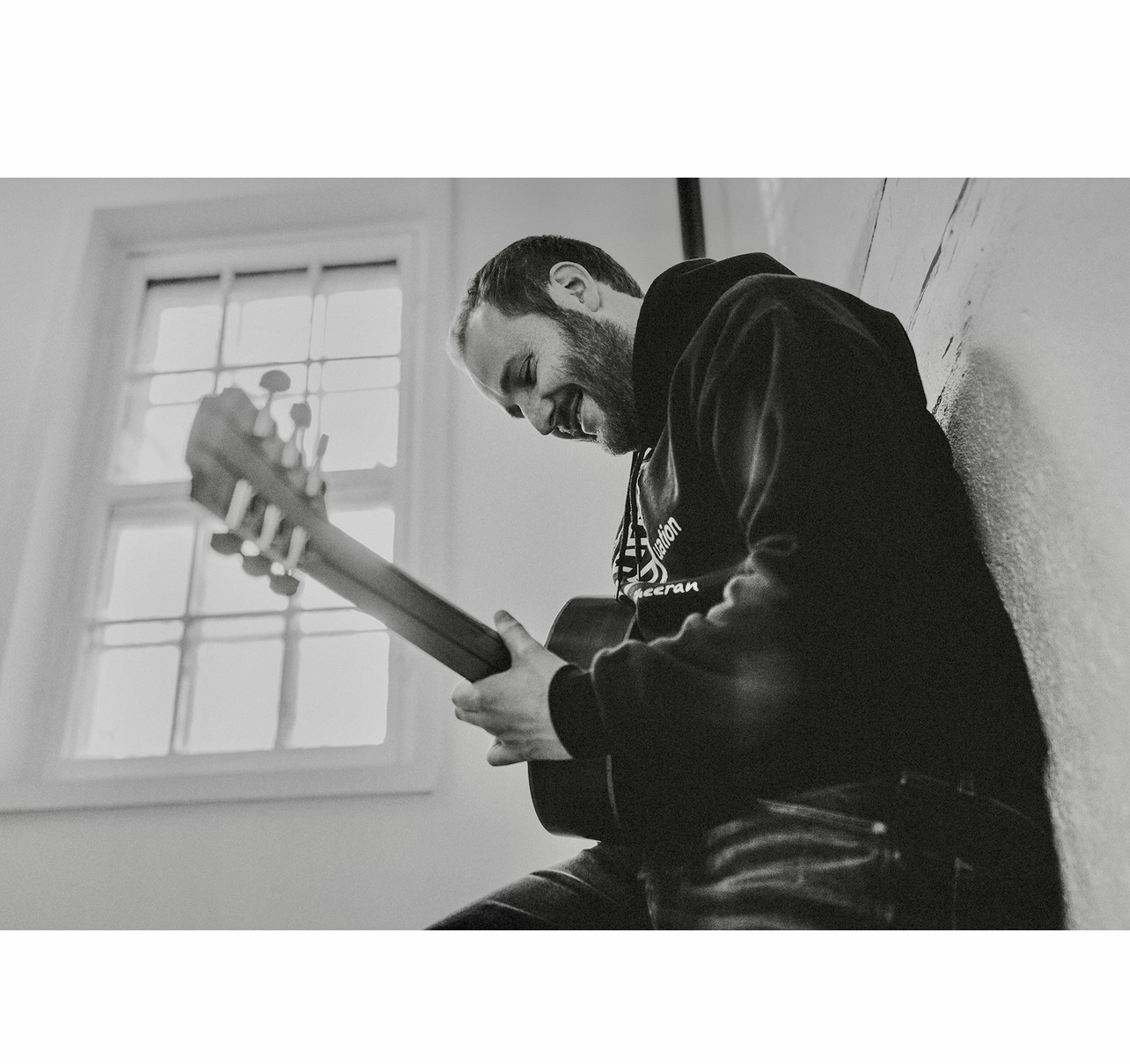 Une photo en noir et blanc d'un homme jouant de la guitare acoustique à Québec.