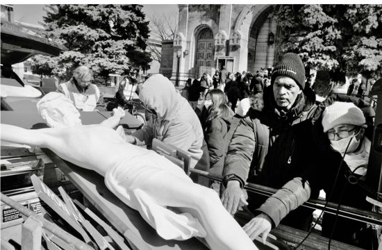 Un groupe de personnes debout autour d’une statue de Jésus pendant Pâques à Montréal.