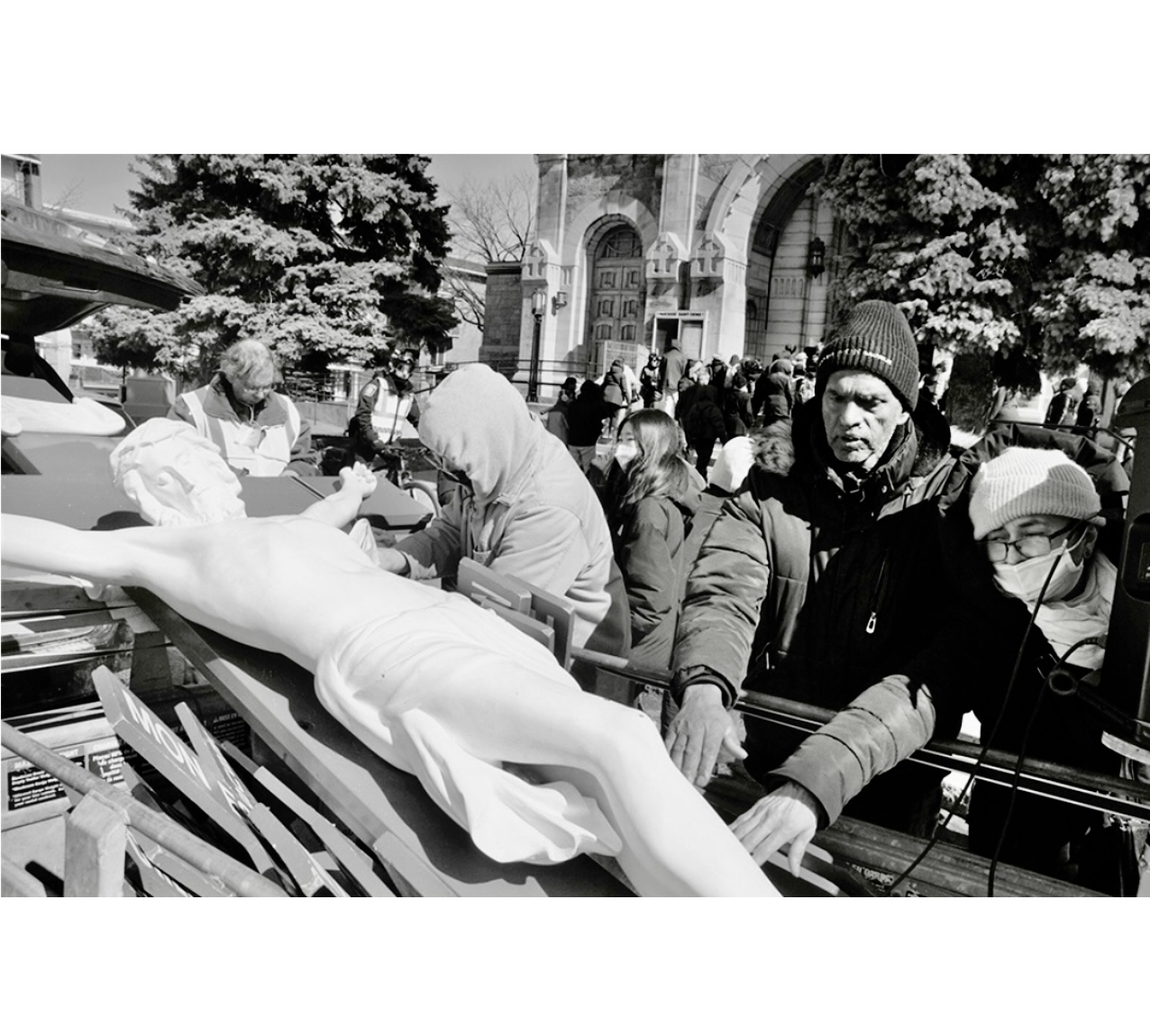Un groupe de personnes debout autour d’une statue de Jésus pendant Pâques à Montréal.