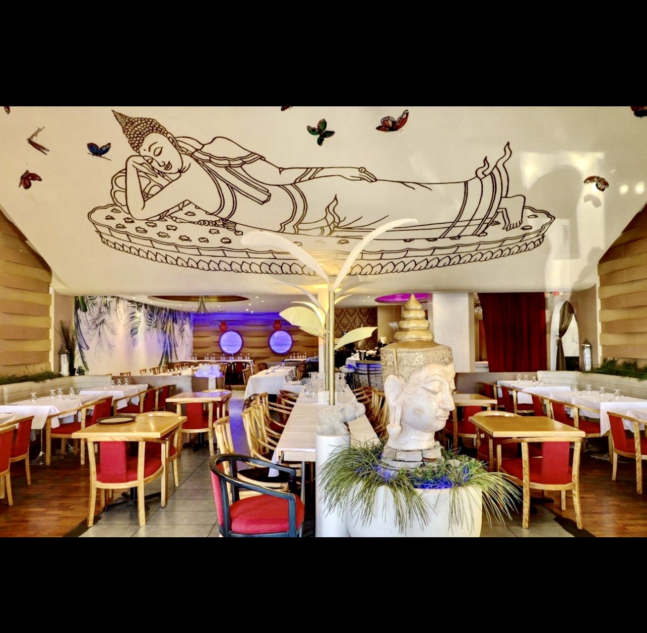 Sawadika, un restaurant avec une grande fresque murale au mur.