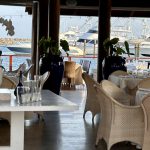 Un restaurant avec des tables et des chaises près d'une marina à Casa de Campo en République Dominicaine.