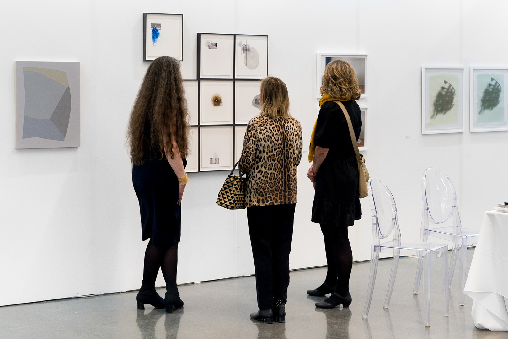 Trois femmes examinant les œuvres d'art exposées dans une galerie d'art.