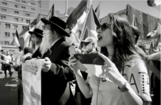 Un groupe de personnes brandissant des pancartes lors d’une Marche pro-palestinienne, capturé sur une photo en noir et blanc.