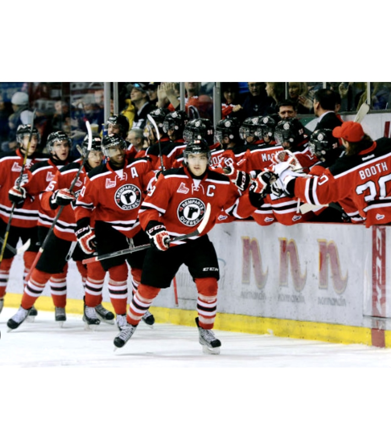 Un groupe de joueurs de hockey québécois célébrant un but dans la ville des champions.