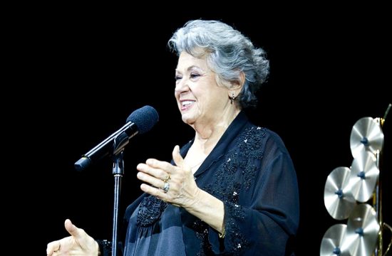 Une femme âgée en prestation au 33e gala annuel de la SOCAN, chantant dans un microphone.