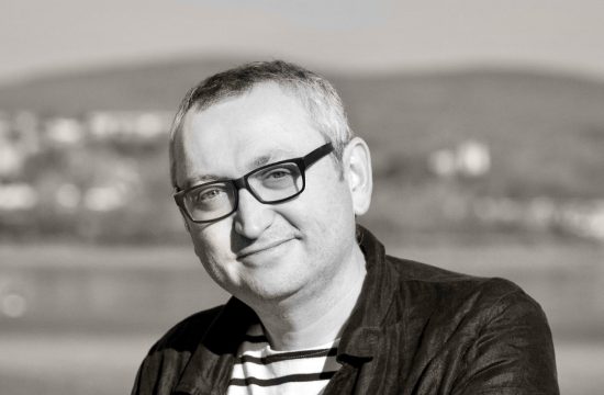 Une photo en noir et blanc d'un homme portant des lunettes et une chemise rayée nommé Mathieu Simoneau.