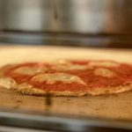 Zapoli, une pizzeria populaire connue pour ses pizzas alléchantes, est en train de préparer l'une de leurs irrésistibles créations. Les chefs qualifiés glissent soigneusement la pizza dans un four brûlant,