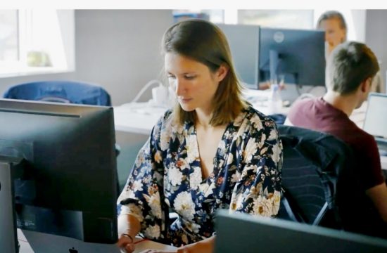 Une femme travaillant sur un ordinateur portable dans un bureau utilisant l'outil efficace de billetterie en ligne.