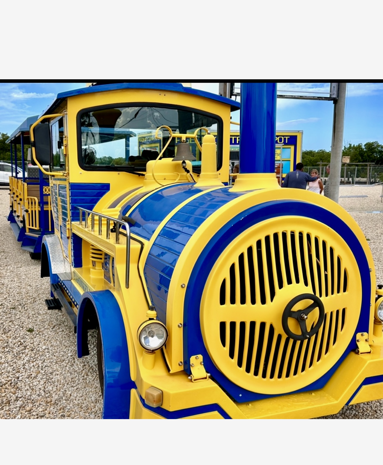 Un train jaune et bleu est stationné sur un parking pour Les Keys en 5 jours jour 2.