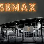 Une photo en noir et blanc d'une grande roue et un panneau indiquant AskMax.