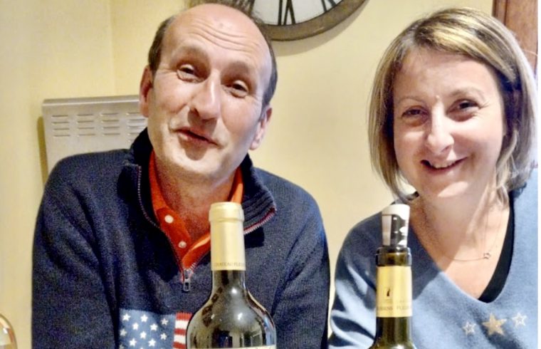 Un homme et une femme tenant joyeusement des bouteilles de vin de Château.