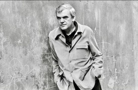 Photo en noir et blanc d'un homme adossé à un mur, rendant hommage à Milan Kundera.