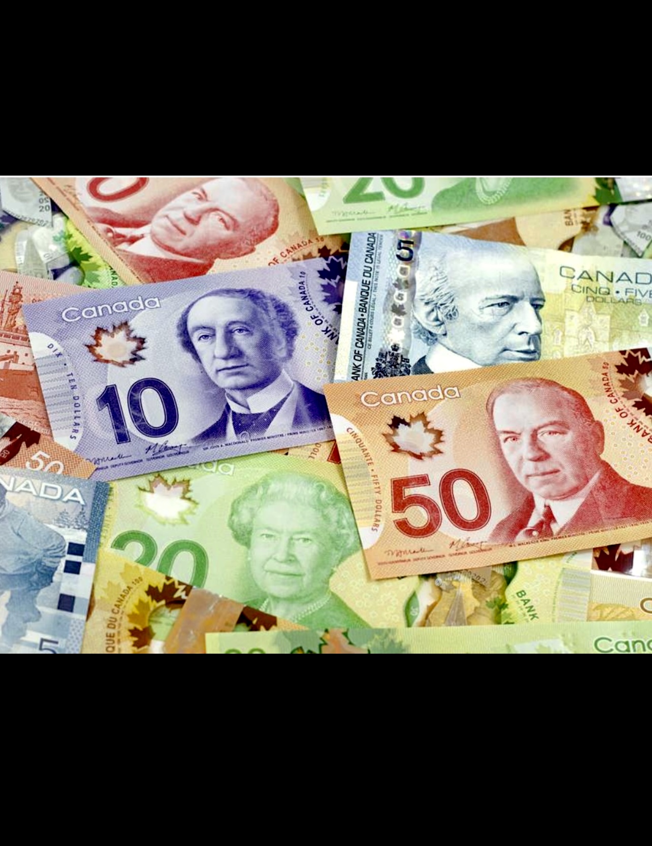 Une pile de billets en monnaie canadienne sur fond noir, avec des taux d'intérêt toujours en hausse !