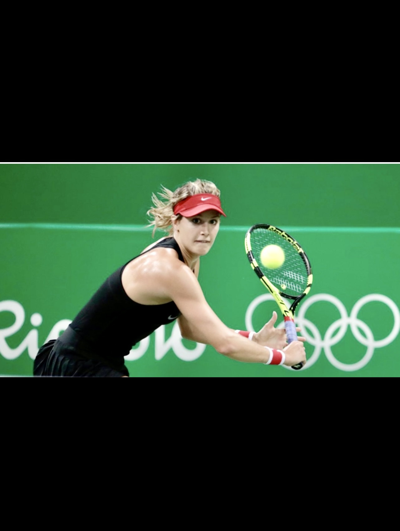 Eugénie Bouchard, une joueuse de tennis, balance gracieusement sa raquette sur une balle, créant une impressionnante démonstration d'habileté et de précision.