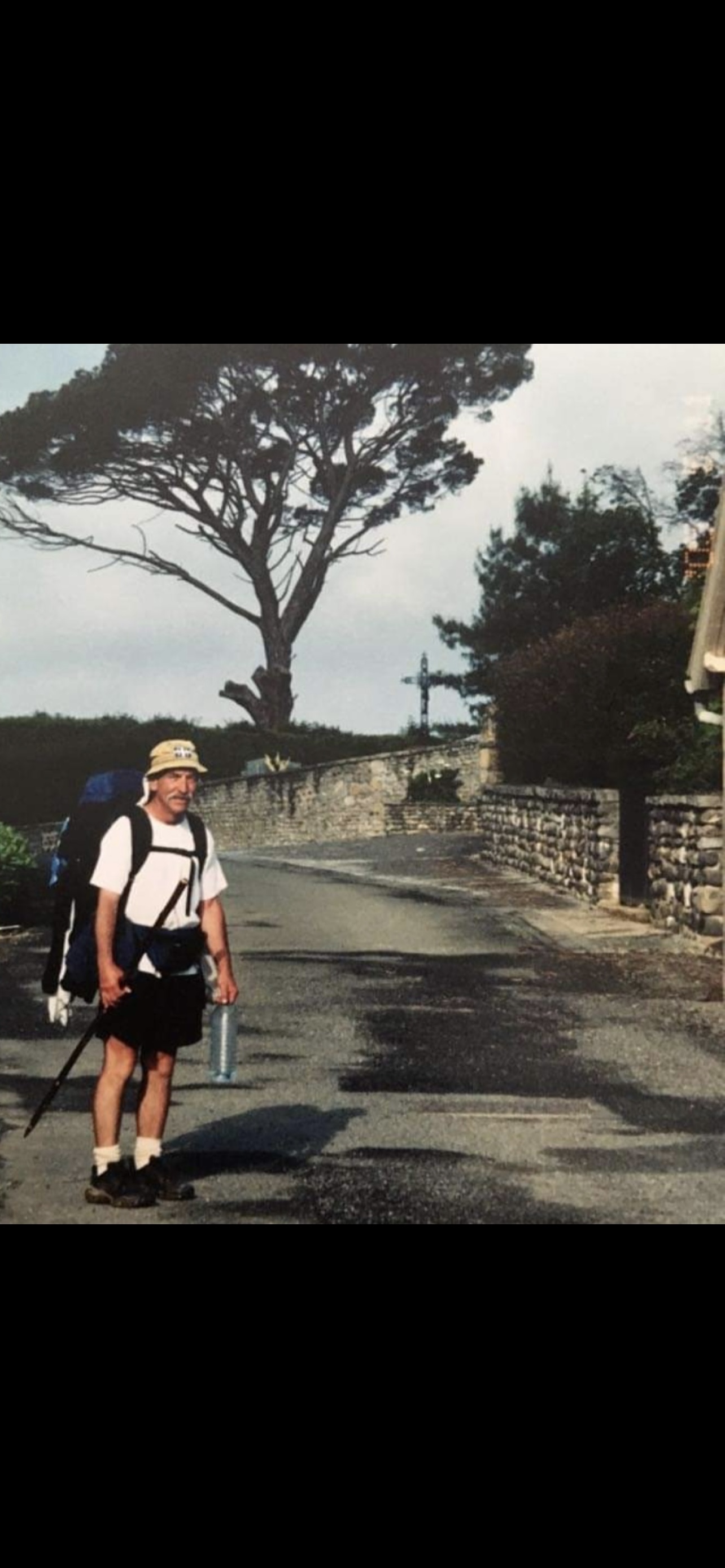 Un homme marchant sur le chemin de Compostelle avec un sac à dos.