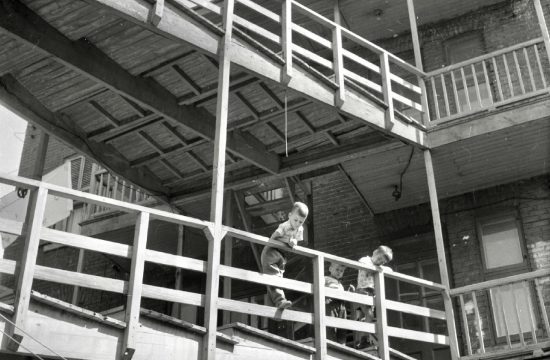 Une photo en noir et blanc d'un homme faisant du skateboard sur un balcon dans le style de "La marche gymnastique sociale II".