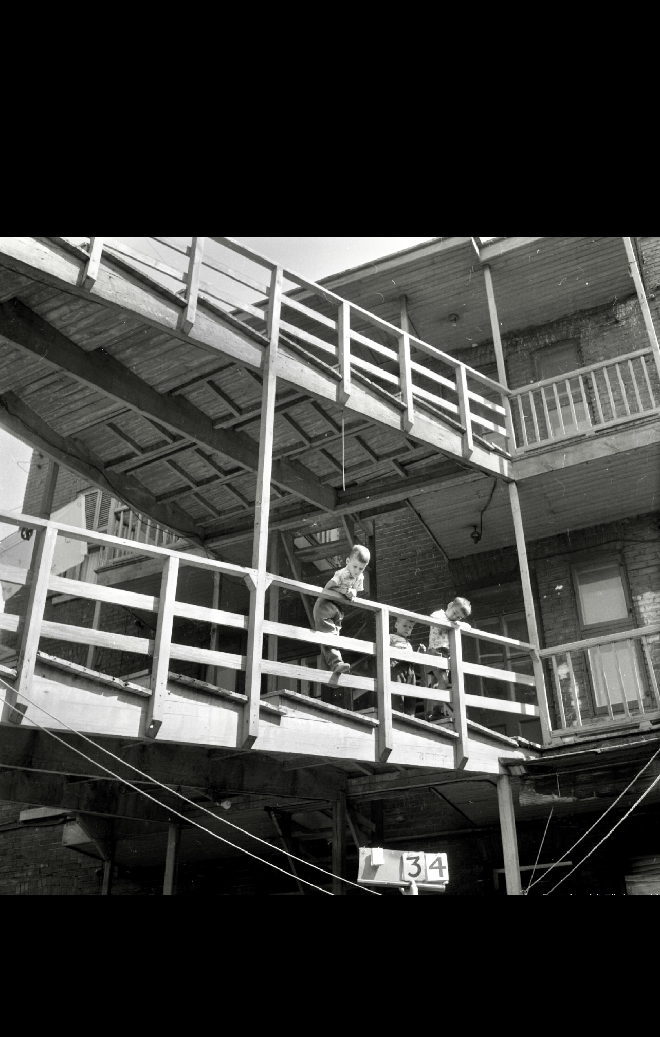 Une photo en noir et blanc d'un homme faisant du skateboard sur un balcon dans le style de "La marche gymnastique sociale II".