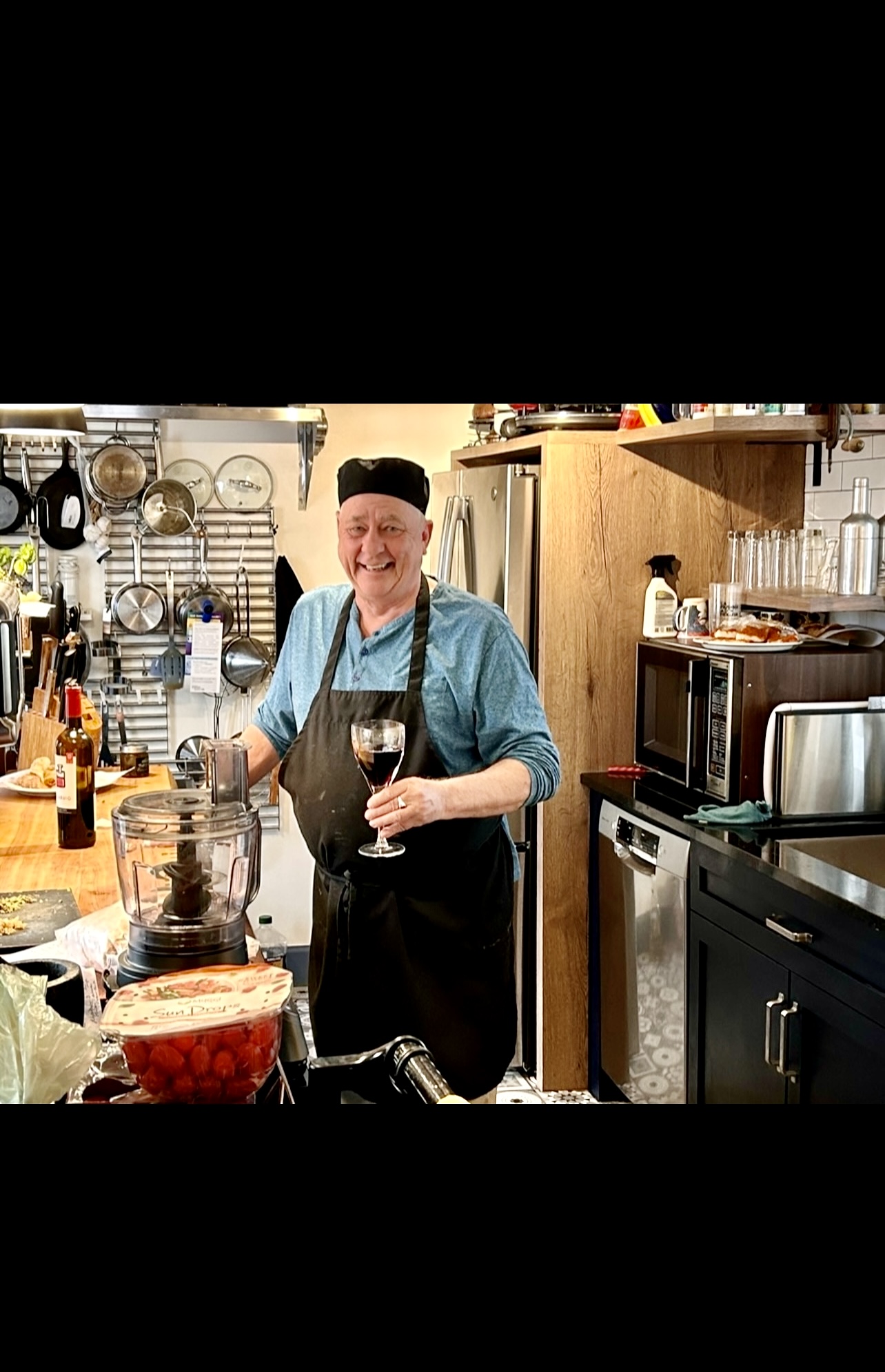 Un homme en tablier debout dans une cuisine de La Maison de l'Île.