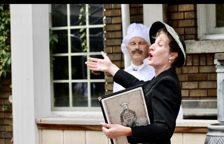 Théâtre déambulatoire à Gatineau : Une femme avec un chapeau et un chapeau tient un livre.