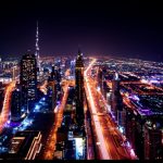 Une vue aérienne de la ville de Dubaï la nuit, mettant en valeur son magnifique horizon et son paysage urbain animé.