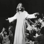 Une photo en noir et blanc de Jésus-Christ devant une foule de personnes.
