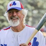 Bill Lee, à barbe blanche, tenant une batte de baseball, représentant les Expos.