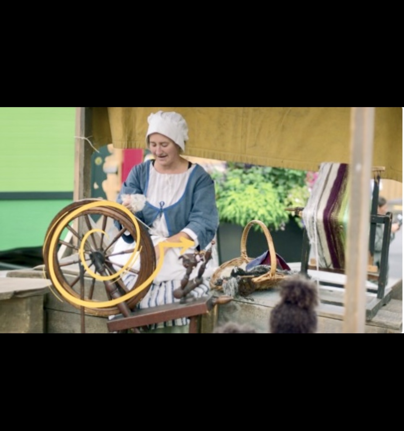 Au Marché public - Pointe-à-Callière, une femme manie habilement un rouet.
