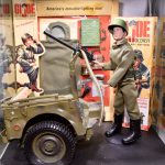 Un G.I. vivant Joe Toy Soldier se tient à côté d’un véhicule militaire.