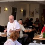 Un groupe de personnes appréciant la douceur de vivre de Cassis à table dans un restaurant.