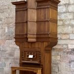 Un vieil orgue en bois avec un banc devant à Lucques.