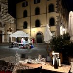 Lucca, un restaurant avec tables et chaises dehors la nuit.