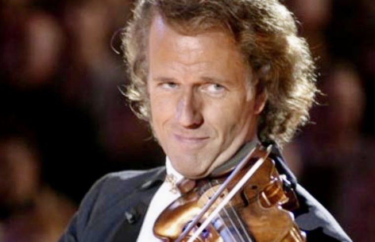 André Rieu, un homme en smoking, jouant du violon.
